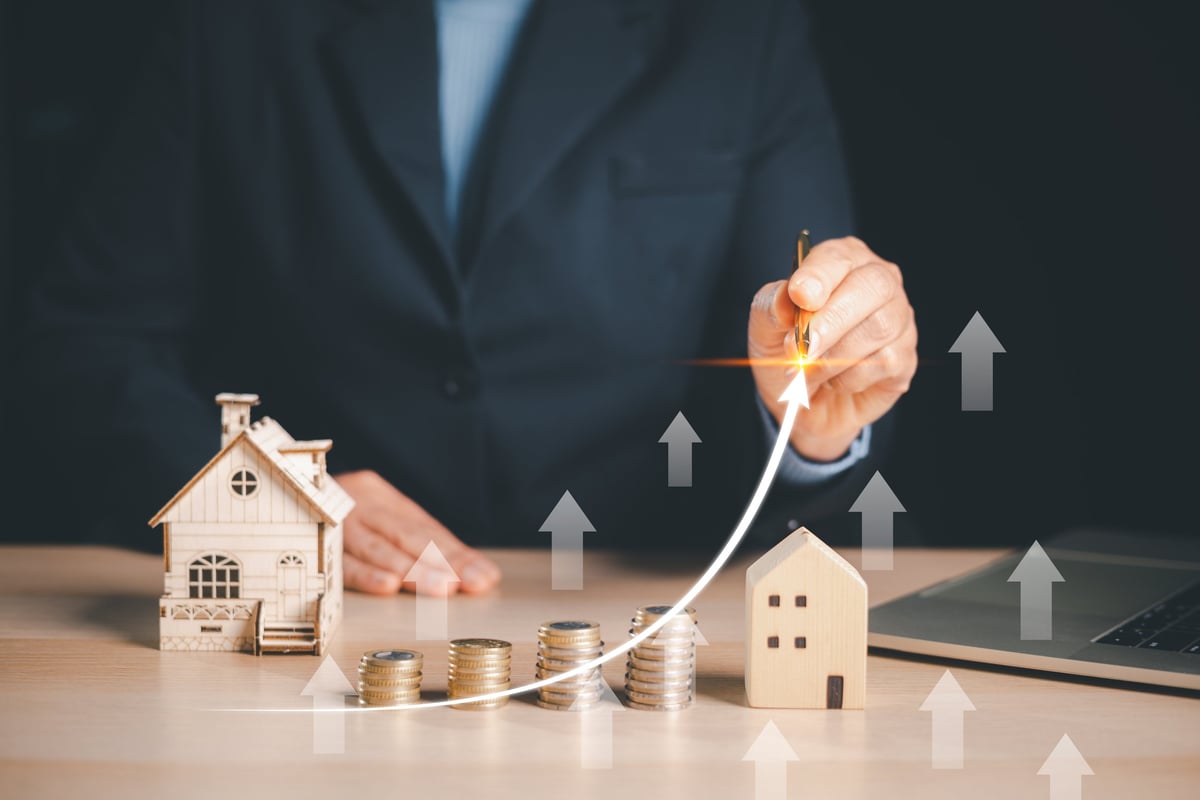 Real estate investment growth concept with property models and rising profit